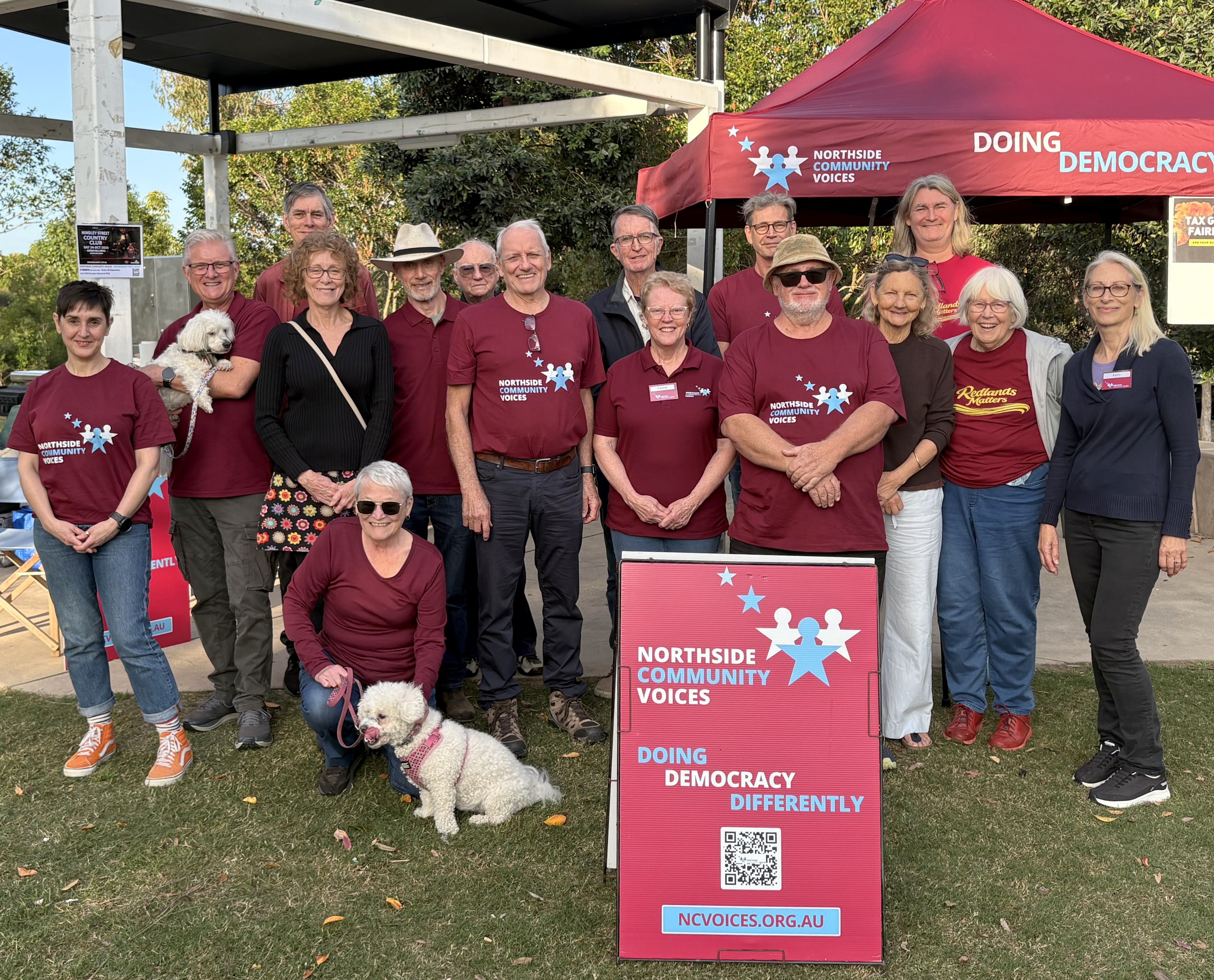 NCV members in maroon shirts gathered by the NCV sign at the barbecue at The Mill Waterpark, Petrie