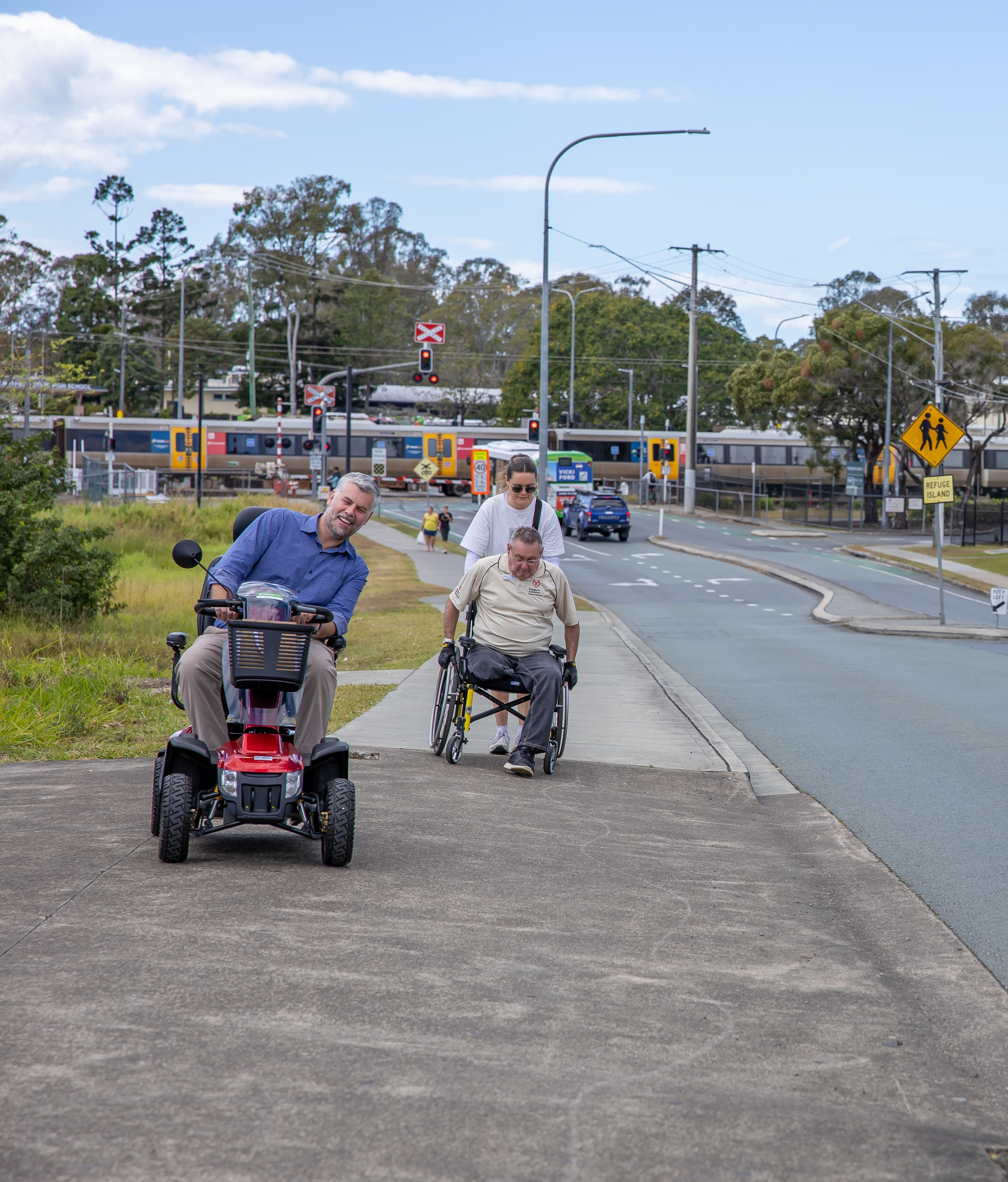 People using a mobility scooter and a walking frame on a sloping footpath near Caboolture Station. Photo supplied by Get Around Caboolture
