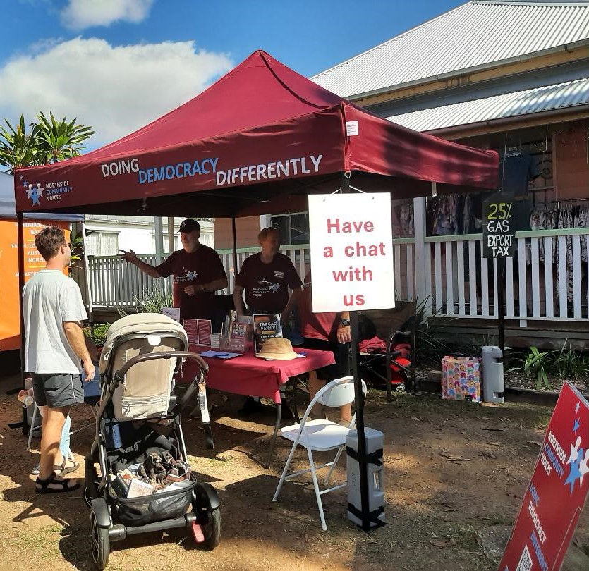 NCV’s maroon marquee stall at Old Petrie Town Markets, with a ‘Have a chat with us’ sign